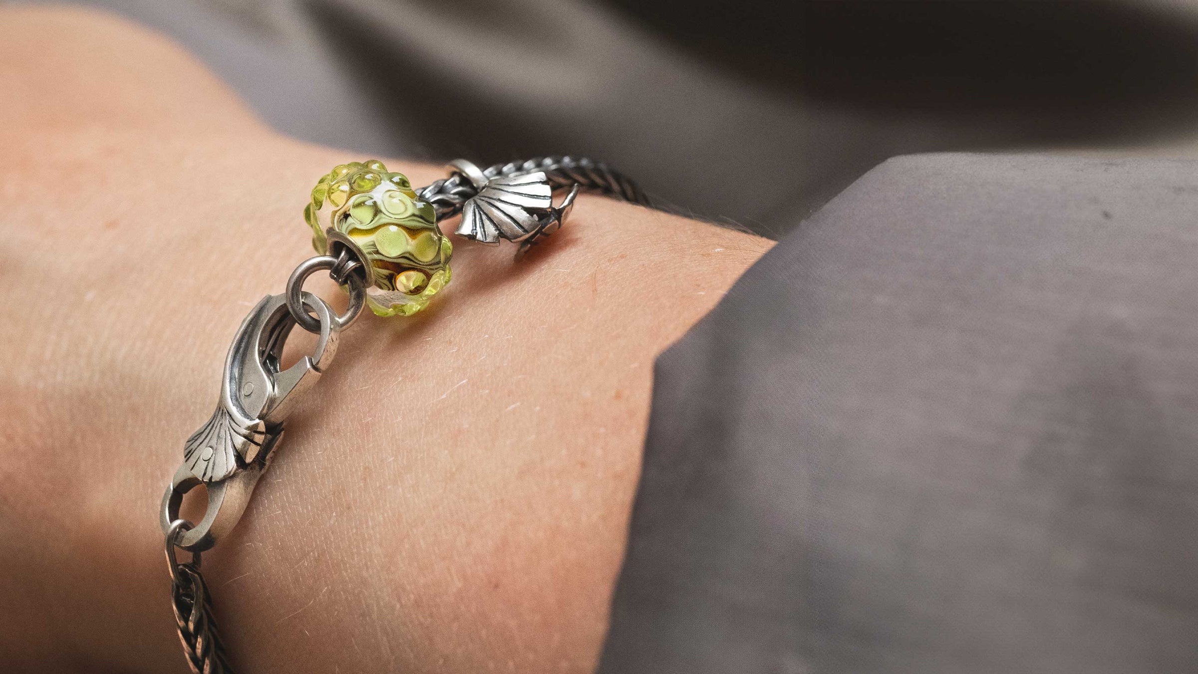 The Eternal Vitality Designer bracelet featuring a silver bead, a stylish silver clasp, and a stunning glass bead in soft green hues.