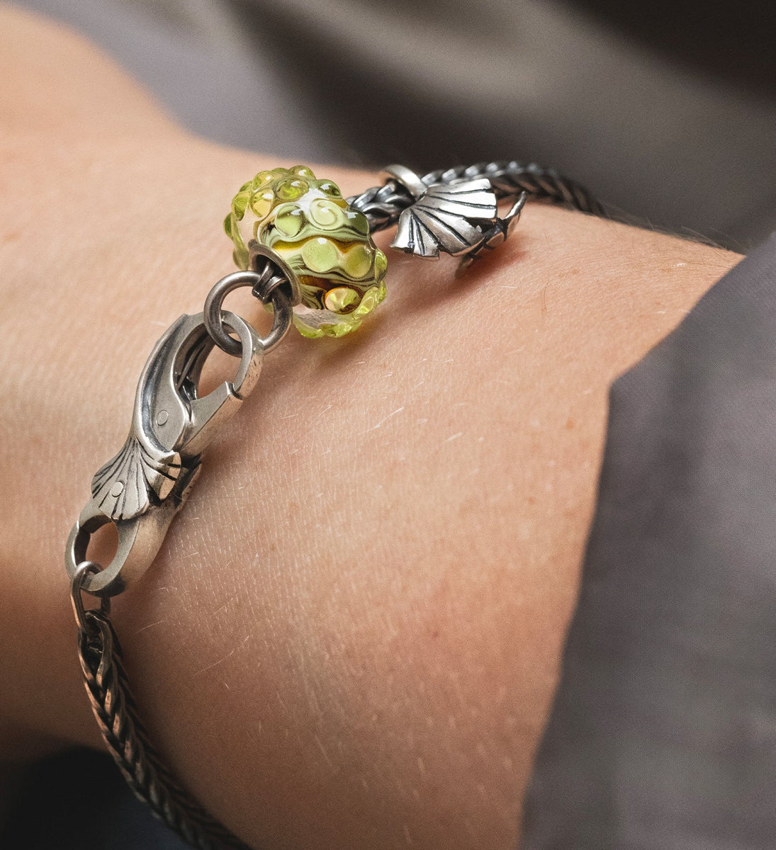 The Eternal Vitality Designer bracelet featuring a silver bead, a stylish silver clasp, and a stunning glass bead in soft green hues.