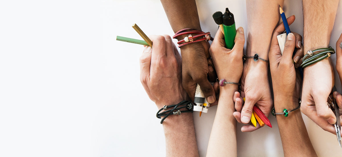 6 hands with every wrist containing a trollbeads bracelet and beads